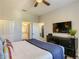 Comfortable bedroom showcasing a large TV, ceiling fan, and ensuite access to the bathroom at 1491 Rolling Fairway Dr, Davenport, FL 33896