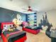 Themed bedroom with red twin beds, a Mickey Mouse mural, and a ceiling fan at 1491 Rolling Fairway Dr, Davenport, FL 33896