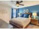 Stylish bedroom with a blue accent wall, wood bed frame, and two bedside lamps at 1491 Rolling Fairway Dr, Davenport, FL 33896