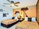 Charming bedroom featuring two twin beds, safari-themed decor, and a ceiling fan at 1491 Rolling Fairway Dr, Davenport, FL 33896