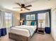 Cozy bedroom featuring a wood bed frame, a blue accent wall, and a ceiling fan at 1491 Rolling Fairway Dr, Davenport, FL 33896