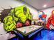 Incredible game room featuring custom murals with superhero theme, and a full sized air hockey table at 1491 Rolling Fairway Dr, Davenport, FL 33896