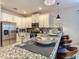 Close up on a modern kitchen island with granite countertops, white cabinets and bar stool seating at 1491 Rolling Fairway Dr, Davenport, FL 33896
