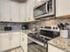 Bright kitchen showcasing stainless steel appliances, granite countertops, a mosaic backsplash, and modern fixtures at 1491 Rolling Fairway Dr, Davenport, FL 33896