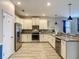 Bright kitchen with stainless steel appliances, white cabinets, granite counters, and tile flooring at 1491 Rolling Fairway Dr, Davenport, FL 33896