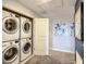 Modern laundry room featuring a stacked washer and dryer, artwork and neutral walls at 1491 Rolling Fairway Dr, Davenport, FL 33896