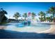 Community splash pool with water features, palm trees, and lounge chairs at 1491 Rolling Fairway Dr, Davenport, FL 33896