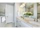 Bright bathroom with double sinks, granite countertops, white cabinets, and a large framed mirror at 15148 Willow Ridge Dr, Montverde, FL 34756
