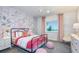 Charming bedroom featuring floral wallpaper, pink accents, and a comfortable iron frame bed at 15148 Willow Ridge Dr, Montverde, FL 34756