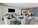 Comfortable living room with modern furniture, a large television, and seamless flow to the kitchen at 15148 Willow Ridge Dr, Montverde, FL 34756