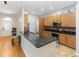 Bright kitchen with granite countertops, wood cabinetry, stainless steel appliances, and a large island at 18 Cooledge St, Winter Garden, FL 34787