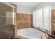 Luxurious main bathroom features soaking tub, separate shower, and large window at 18 Cooledge St, Winter Garden, FL 34787