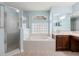 A luxurious bathroom showcasing a soaking tub and separate glass-enclosed shower at 201 Churchill Ct, Kissimmee, FL 34758