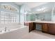 A luxurious bathroom showcasing a soaking tub, separate glass-enclosed shower, and dual sinks at 201 Churchill Ct, Kissimmee, FL 34758
