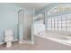 A serene bathroom with a soaking tub, separate glass-enclosed shower, and toilet at 201 Churchill Ct, Kissimmee, FL 34758