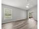 Bright bedroom featuring sleek wood-look floors, large window, and sliding glass door to the lanai at 201 Churchill Ct, Kissimmee, FL 34758