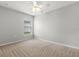 Neutral bedroom features ceiling fan, bright window, and soft carpet at 201 Churchill Ct, Kissimmee, FL 34758