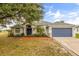 Charming single-story home with blue garage door, mature landscaping, and vibrant red walkway at 201 Churchill Ct, Kissimmee, FL 34758