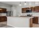 Bright kitchen features a breakfast bar, stainless steel appliances, and wood cabinets at 201 Churchill Ct, Kissimmee, FL 34758