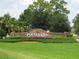Poinciana community entrance with beautiful stone signage and manicured landscaping at 201 Churchill Ct, Kissimmee, FL 34758