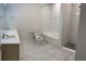 A bright bathroom featuring marble floors, dual sinks, and a stylish tiled shower and tub at 2025 Claudia Ln # 2025, Kissimmee, FL 34741