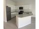 Modern kitchen featuring granite countertops, white cabinets, and stainless steel appliances at 2025 Claudia Ln # 2025, Kissimmee, FL 34741