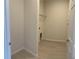 A compact laundry room with tile flooring and shelving for storage solutions at 2025 Claudia Ln # 2025, Kissimmee, FL 34741