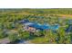 Aerial view of a stunning community pool surrounded by palm trees and lush landscaping at 2490 Southlawn Ln, Clermont, FL 34714