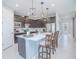 Modern kitchen featuring a large island with seating, dark wood cabinets, and stainless steel appliances at 2490 Southlawn Ln, Clermont, FL 34714