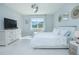 Bright main bedroom with white bed, dresser, and tile floors. Large windows provide a view of outside at 2490 Southlawn Ln, Clermont, FL 34714
