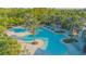 Community pool with palm trees, splash pad, and various tables with umbrellas at 2490 Southlawn Ln, Clermont, FL 34714