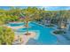 Community pool with palm trees, splash pad, and various tables with umbrellas at 2490 Southlawn Ln, Clermont, FL 34714