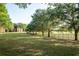Spacious green lawn with mature trees is enclosed by a black metal fence at 2586 Robert Trent Jones Dr # 1116, Orlando, FL 32835