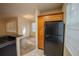 Kitchen with black appliances, wood cabinets and a view into the living area with wood floors at 2586 Robert Trent Jones Dr # 1116, Orlando, FL 32835