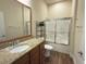 Bright bathroom with granite counters, wood cabinets and a glass-enclosed shower at 2611 Shantiniketan Blvd # G-11, Tavares, FL 32778