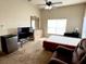 Well-lit bedroom with a ceiling fan, dresser, and mini-fridge at 2611 Shantiniketan Blvd # G-11, Tavares, FL 32778