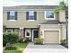 Charming townhome featuring a one car garage, landscaped yard, and classic architectural details at 2667 River Landing Dr, Sanford, FL 32771