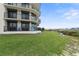 Exterior view of a modern condo building with balconies overlooking the water and lush landscaping at 2700 N Peninsula Ave # 314, New Smyrna Beach, FL 32169