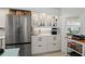 Bright white kitchen featuring stainless steel refrigerator and cabinets with glass doors at 2700 N Peninsula Ave # 314, New Smyrna Beach, FL 32169