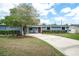 Charming single-story home with a well-manicured front yard, red front door and long driveway at 2707 Prince John Rd, Winter Park, FL 32792