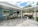 Spacious covered patio with outdoor seating and a view of the landscaped backyard at 2707 Prince John Rd, Winter Park, FL 32792