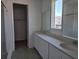 Modern bathroom with white cabinets, dual sinks, walk-in shower, and large mirror at 2976 Embark Trail, St Cloud, FL 34771