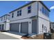 Modern gray and white two-story townhome with a two-car garage and concrete driveway at 2976 Embark Trail, St Cloud, FL 34771