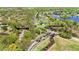 Aerial view showcasing the community entrance, Flagler Trail, and lush surrounding landscape at 318 Osprey Lakes Cir, Chuluota, FL 32766