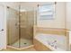 Bright bathroom with a large soaking tub, a glass-enclosed shower, and beautiful neutral tiling at 318 Osprey Lakes Cir, Chuluota, FL 32766