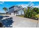 Side view of a well-maintained home with a three-car garage and manicured landscaping at 318 Osprey Lakes Cir, Chuluota, FL 32766