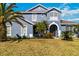 Charming home exterior with lush lawn, mature palms, and welcoming architectural details at 318 Osprey Lakes Cir, Chuluota, FL 32766