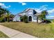 Home's front exterior featuring manicured lawn, mature palms, and inviting entrance at 318 Osprey Lakes Cir, Chuluota, FL 32766