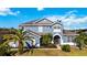 Charming two-story home with well-manicured lawn and lush landscaping, including palm trees at 318 Osprey Lakes Cir, Chuluota, FL 32766
