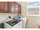 Bright laundry room featuring front-load washer/dryer, storage cabinets, and a sunlit window at 318 Osprey Lakes Cir, Chuluota, FL 32766